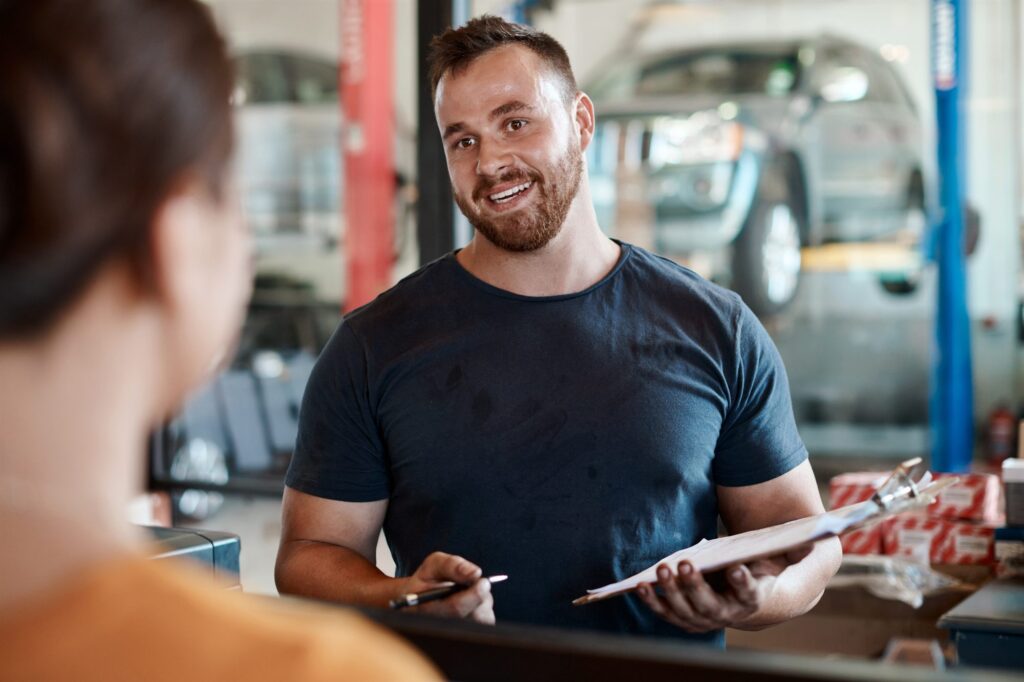 Serviceberater bespricht mit einer Kundin den Werkstattauftrag